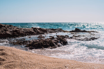 Fototapeta na wymiar Una orilla con olas y espuma en la costa brava