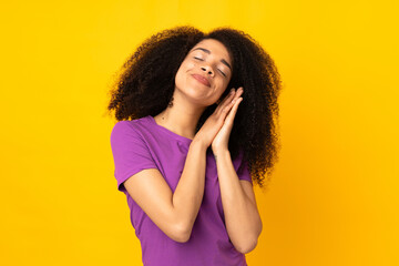 Young african american woman over isolated background making sleep gesture in dorable expression