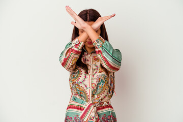 Young Indian woman isolated on white background keeping two arms crossed, denial concept.