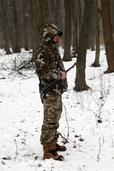 Fototapeta premium The man with machine gun in the snowy forest