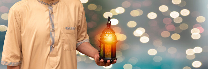Arab Muslim man holding lantern ready for eid and Ramadan Mubarak.  Month of fasting for Muslims. islamic background