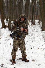 A soldier with hand grenade in the snowy forest