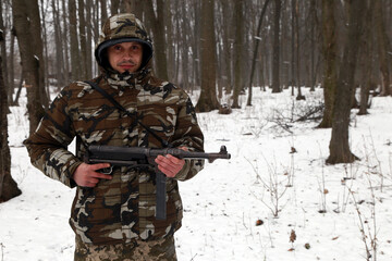 Fototapeta premium Gangster with a machine gun in the snowy forest