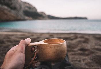person on the beach with a cup