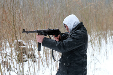 The man with vintage german machine gun in the forest in winter