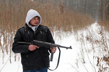 The man with vintage german machine gun in the forest in winter