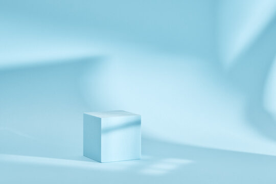 Blue background for product presentation with shadows and light. Empty cubic podium. Mockup.