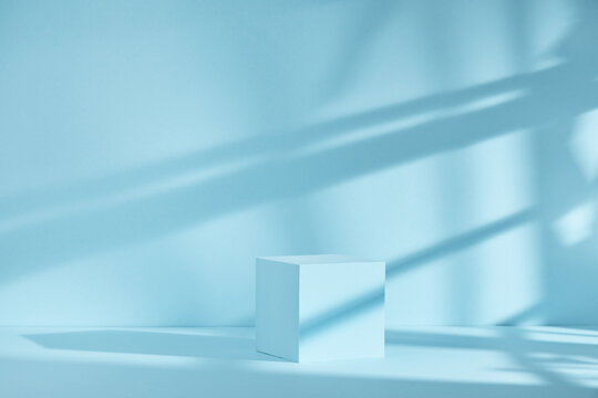 Blue background for product presentation with shadows and light. Empty cubic podium. Mockup.