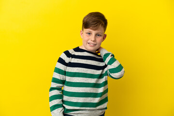 Little redhead boy isolated on yellow background laughing