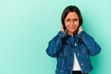 Young mixed race woman isolated on blue background touching back of head, thinking and making a choice.