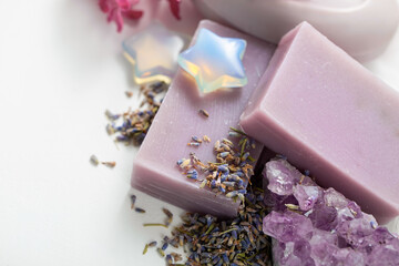 Handmade natural soap, dried lavender flowers, amethyst and moonstone crystal on a white background. Spa care and water treatment items with copy space