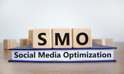 SMO, social media optimization symbol. Wooden cubes on book with word 'SMO - social media optimization' on beautiful white background, copy space. Business, SMO - social media optimization concept. - obrazy, fototapety, plakaty