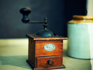 Vintage coffee grinder. Defocused background. Film grain texture. Close up