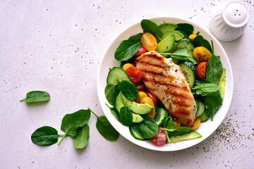 Fresh vegetable salad with grilled chicken fillet. Top view with copy space.