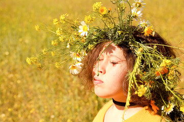 Girl with wreath on head in the field.