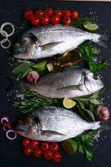 Raw dorado fish or sea bream with ingredients for making. Top view with copy space.