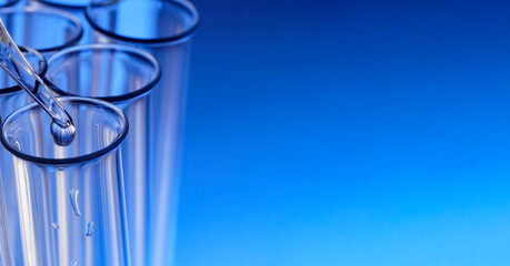 glass test tube with dropper on blue background with substance