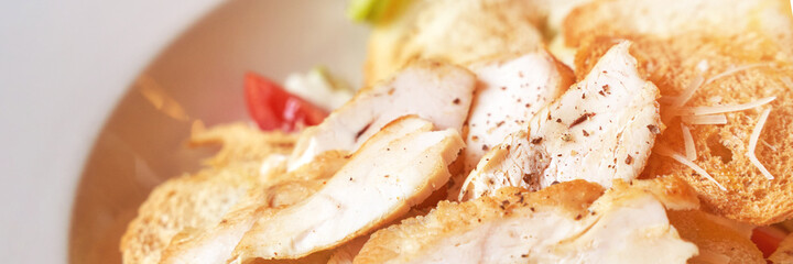 Caesar salad plate. Health food at cafe. Bread crouton, chicken, tomato, cheese in bowl. Top view. Closeup view. Freeshness gourmet. Italian cuisine. Horizontal banner