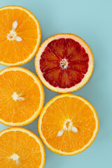 Group from  red and yellow slices of oranges on blue background. Citrus fruit background and copy space