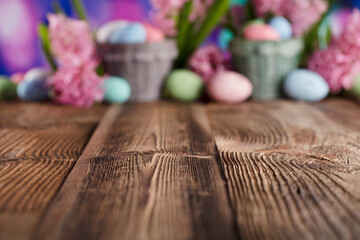 Easter background.  Easter eggs and spring flowers. Rustic wooden table. Pastel colors bokeh. Place for typography.