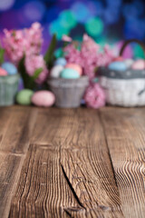 Easter background.  Easter eggs and spring flowers. Rustic wooden table. Pastel colors bokeh. Place for typography.