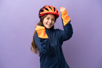 Little caucasian girl isolated on purple background celebrating a victory