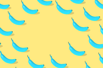 Obraz premium Trendy Summer pattern made with fresh banana fruit colored in blue on bright yellow background.