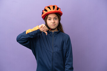 Little caucasian girl isolated on purple background showing thumb down with negative expression