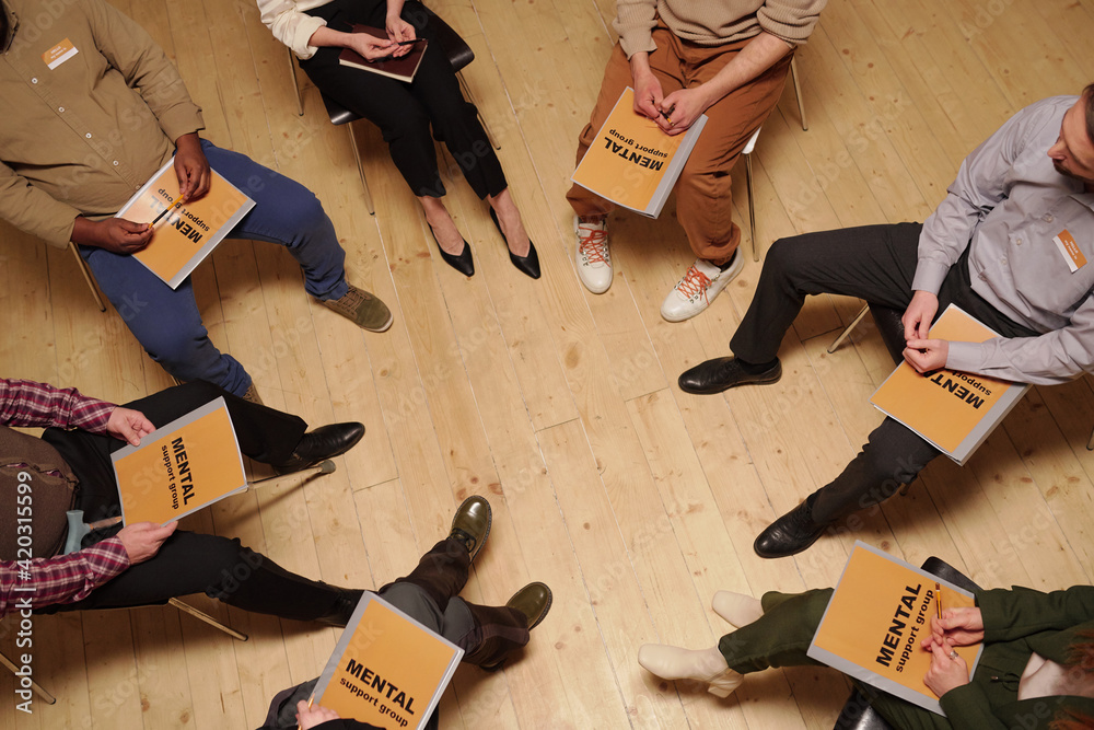 Poster Overview of large group of patients with journals of mental group support sitting in circle
