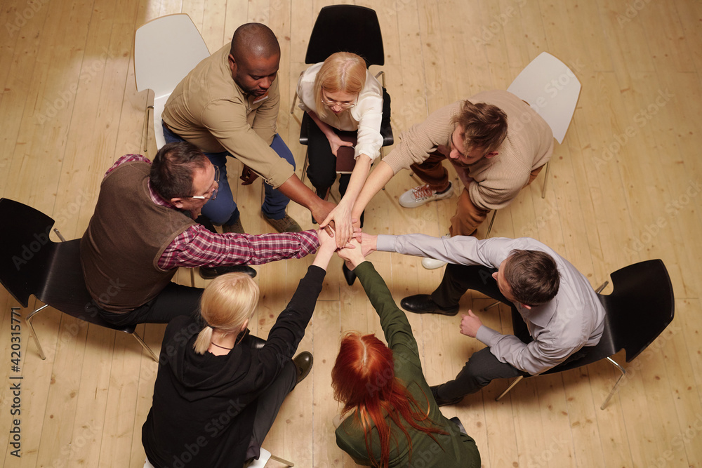 Poster overview of several intercultural patients of mental group support making pile of hands