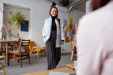 Young happy beautiful caucasian woman in cozy modern cafe