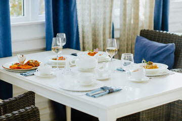 Lunch tablecloth with food and glasses of white wine with tea set