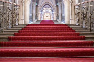 Red carpet on the steps of the building. Staircase in a palace