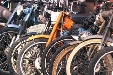 rangée de plusieurs anciens mobylettes, vélosolex et motos