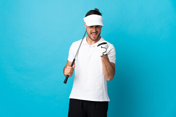 Young handsome man isolated on blue background playing golf and celebrating a victory