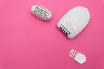 White electric epilator for hair on pink background. Beauty concept