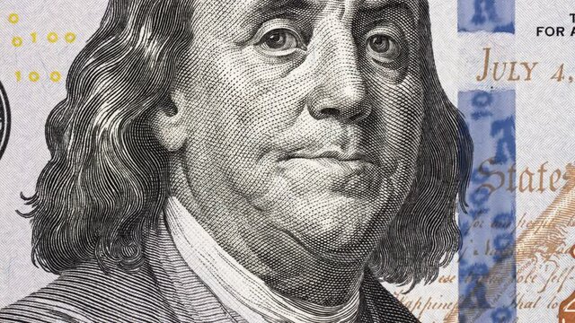 Benjamin Franklin on US 100 dollar bill tilting. Slider shot. 4K