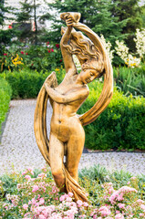 Złoty posąg półnagiej kobiety z długimi włosami.