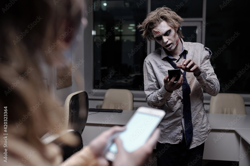 Aufkleber dead and spooky businessman with zombie greasepaint on face and hands scrolling in smartphone