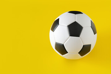 Classic soccer ball on yellow background. Minimal creative concept, copy space 