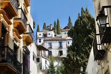 Fototapeta na wymiar View of the Granada neighborhood of Realejo (Spain) with its typical white houses with cypress trees