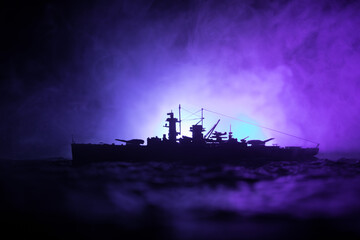 Silhouettes of a crowd standing at blurred military war ship on foggy background. Selective focus....