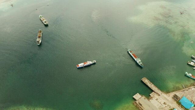 Freight ships and ferries in the bay, aerial view. Dapa Ferry Terminal. Siargao, Philippines.