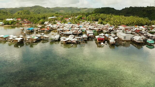 Village of stilt houses built over the sea, top view. Dapa, Siargao, Philippines.