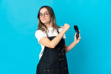 Young Romanian hairdresser woman isolated on blue background proud and self-satisfied