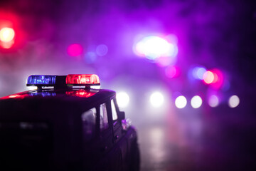 Police cars at night. Police car chasing a car at night with fog background. 911 Emergency response police car speeding to scene of crime.