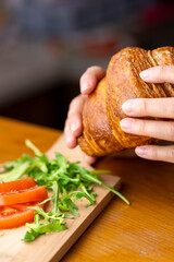 Woman Having Delicious Fresh Croissant For Breakfast. Selective focus.
