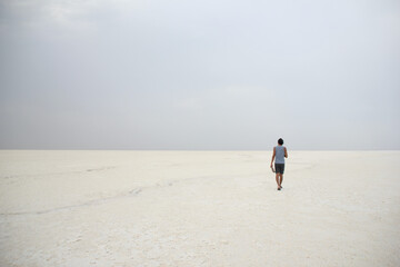 person walking in a salt desert