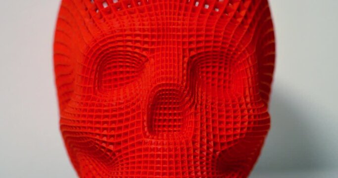 Skull printed with plastic of red color on a 3d printer.