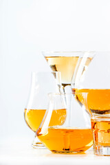 Hard strong alcoholic drinks and distillates in glasses and shot glass in assortment: vodka, cognac, tequila, scotch, brandy and whiskey, grappa, liqueur, vermouth, tincture, rum. White background